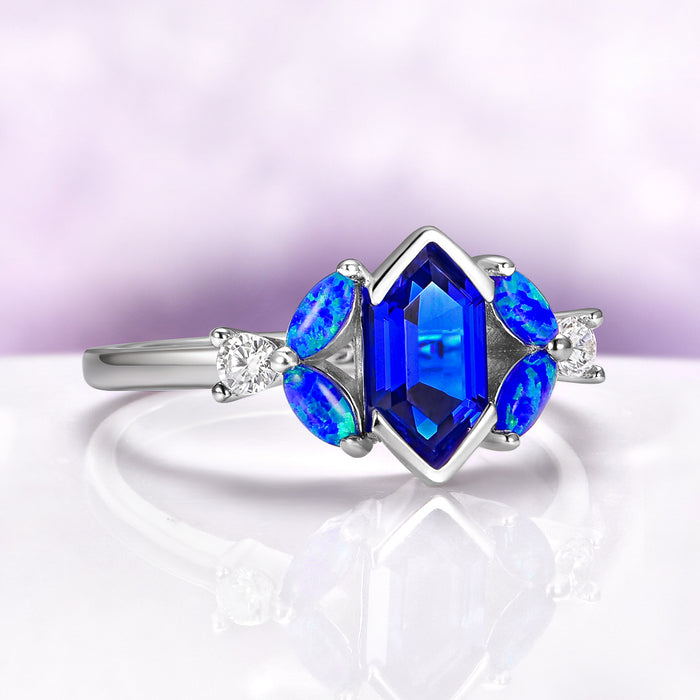 Hexagon Sapphire Blue Opal Engagement Ring in Sterling Silver by Aquamarise, featuring a geometric blue sapphire centerpiece with vibrant blue opal accents and sparkling side diamonds.