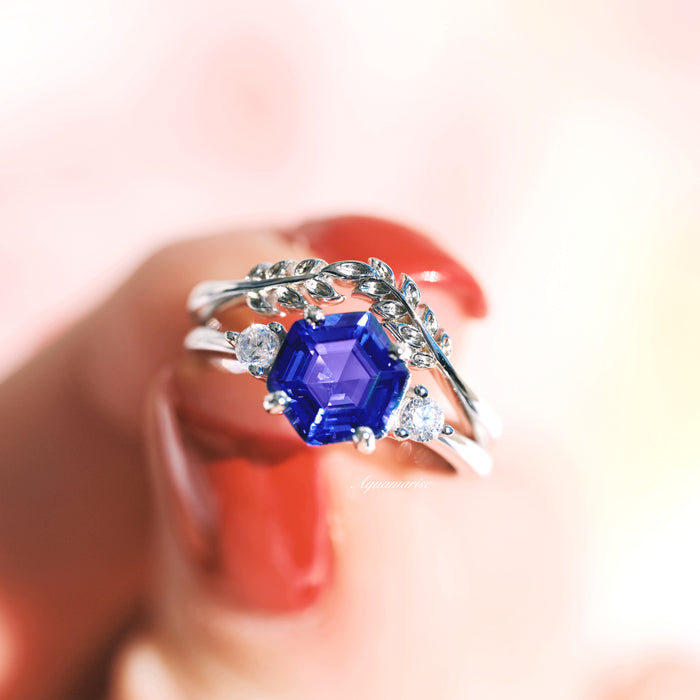 Hexagon Tanzanite Leaf Ring Set in Sterling Silver featuring a vibrant hexagon-cut blue tanzanite with sparkling accents and delicate leaf-inspired bands by Aquamarise.