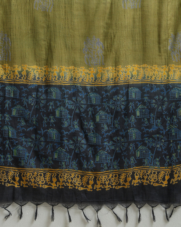 Unstitched Katan silk suit set with deep indigo panels block printed in folk figure silhouettes and geometric shapes, a plain olive green piece, and mustard yellow figurative border bands at the edges and dupatta ends.