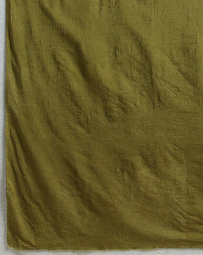 Unstitched Katan silk suit set with deep indigo panels block printed in folk figure silhouettes and geometric shapes, a plain olive green piece, and mustard yellow figurative border bands at the edges and dupatta ends.