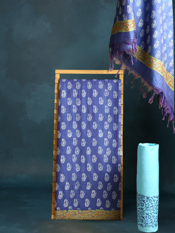Indigo Katan silk unstitched suit set with all-over small paisley block print, pale blue decorative bands with yellow and green accents, and a fringed dupatta
