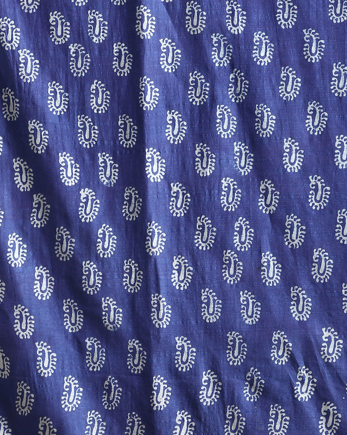 Indigo Katan silk unstitched suit set with all-over small paisley block print, pale blue decorative bands with yellow and green accents, and a fringed dupatta