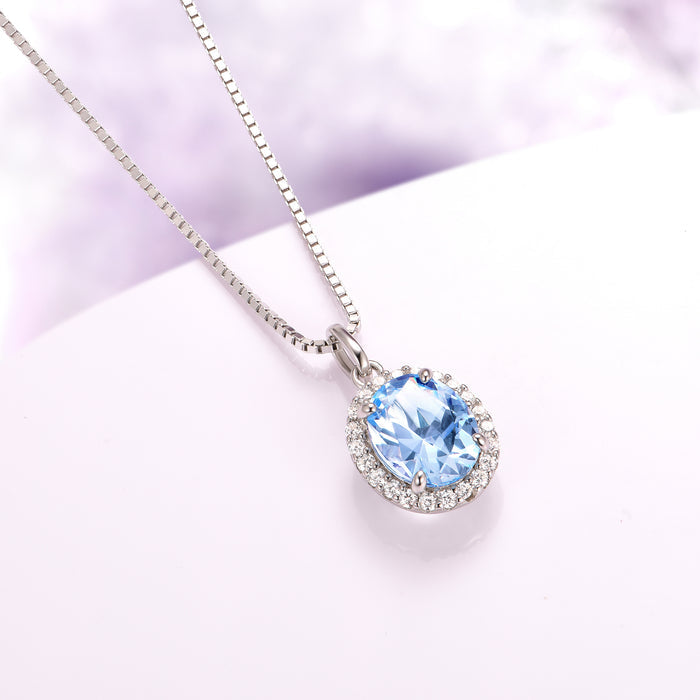 Iris Halo Oval Aquamarine Necklace in Sterling Silver by Aquamarise featuring a 2.3 ct simulated aquamarine surrounded by sparkling simulated diamonds, perfect for March birthstone gifts.
