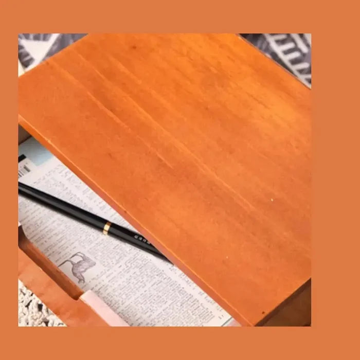 Japanese wooden desk organizer with a smooth top surface and a pen resting inside.