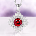 Joelle Natural Red Garnet Starburst Pendant Necklace in Sterling Silver featuring a vibrant garnet center surrounded by sparkling baguette and round accents by Aquamarise.