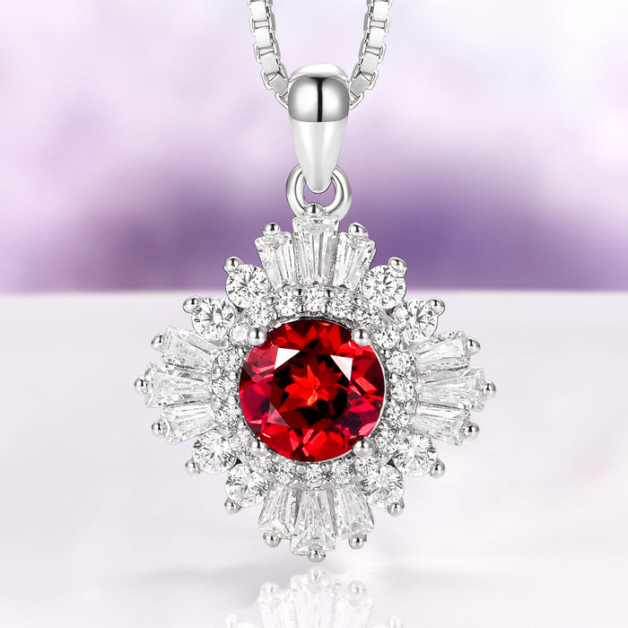 Joelle Natural Red Garnet Starburst Pendant Necklace in Sterling Silver featuring a vibrant garnet center surrounded by sparkling baguette and round accents by Aquamarise.