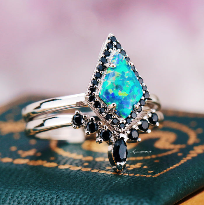 Galaxy Green Fire Opal Couples Ring Set by Aquamarise featuring a vibrant diamond-shaped green fire opal surrounded by black stones on polished silver bands symbolizing unity and love.