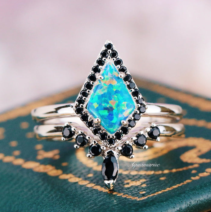 Galaxy Green Fire Opal Couples Ring Set by Aquamarise featuring a diamond-shaped opal with vibrant green-blue hues, accented by small black stones on polished silver bands symbolizing unity.