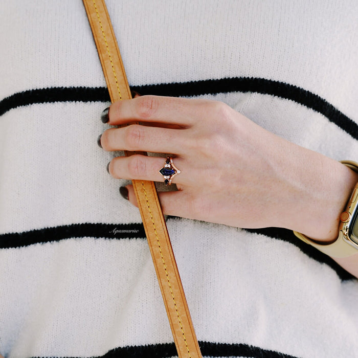 Starry Night Coffin Kite Engagement Ring Set in 14K Solid Rose Gold featuring a deep blue coffin kite gemstone and delicate rose gold details on a hand holding a tan leather bag strap.