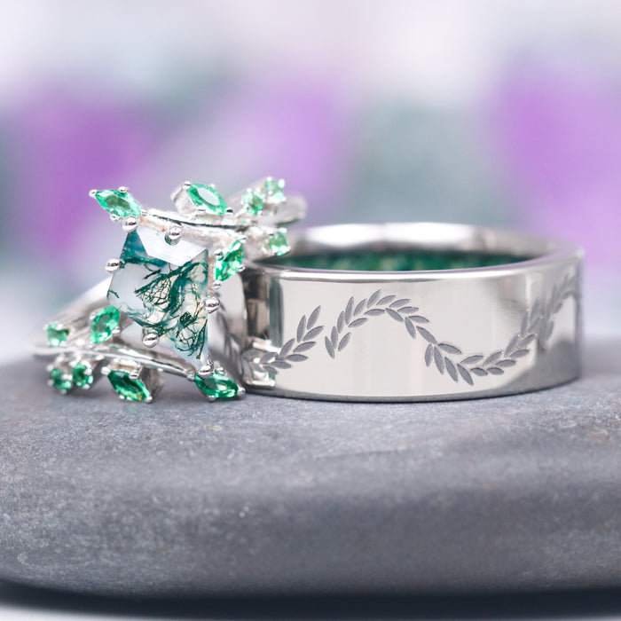 Kite Moss Agate & Emerald Leaf Couples Ring Set featuring a square moss agate center stone surrounded by small emerald leaves and a coordinating silver band engraved with a delicate leafy vine, crafted by Aquamarise.