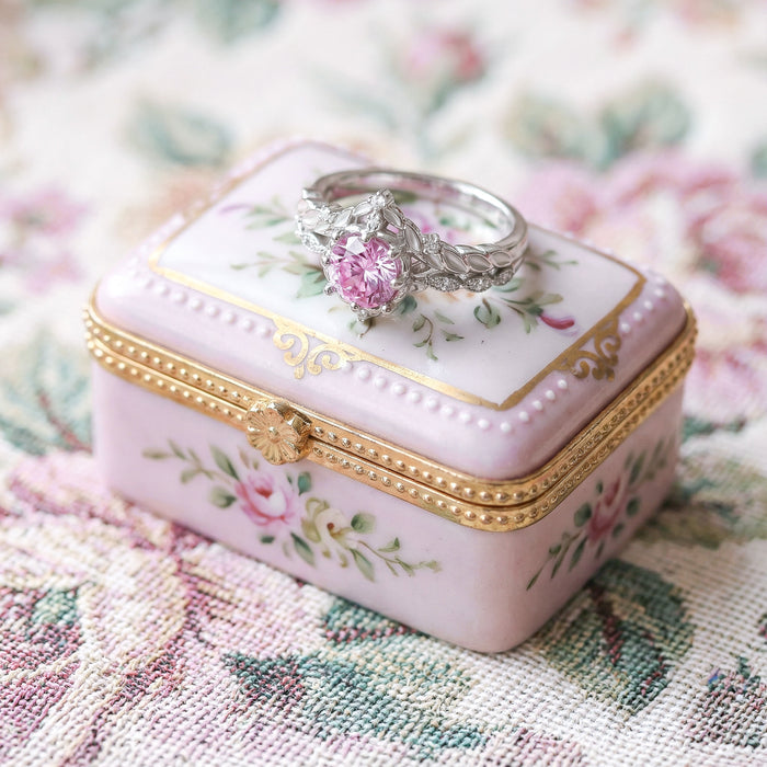 Engagement ring on a decorative pink jewelry box with floral patterns