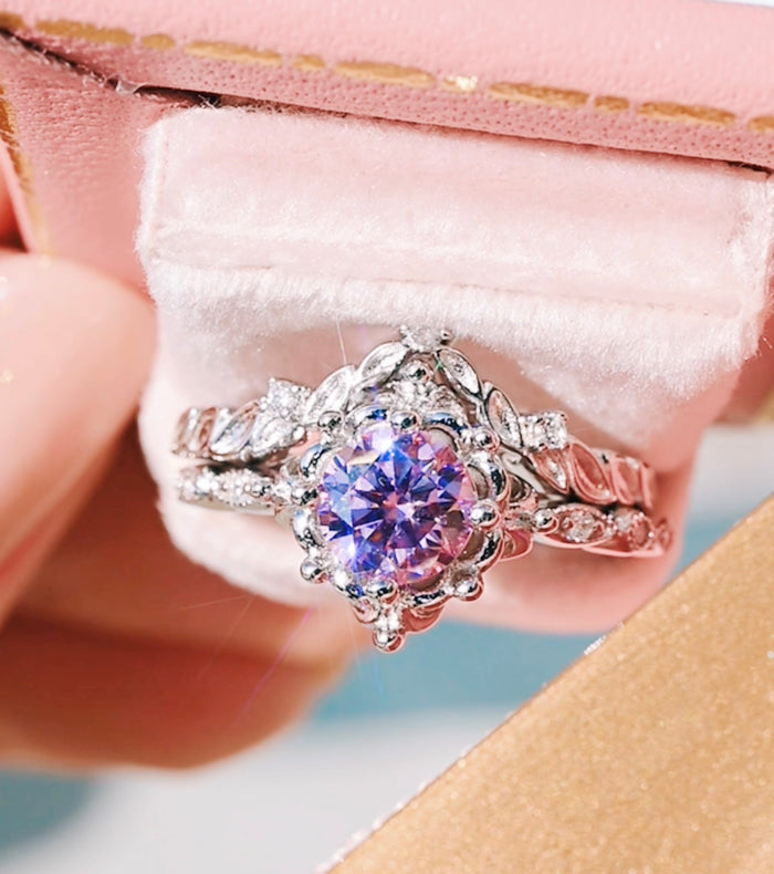 Silver ring with a purple gemstone in a pink jewelry box