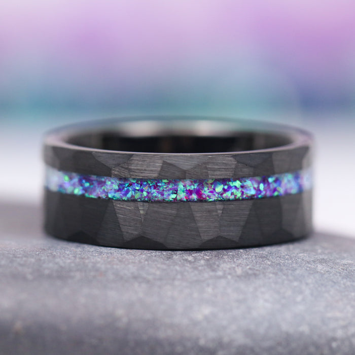 Lavender Fire Opal & Emerald Leaf Couples Ring Set by Aquamarise, featuring a black finish band with a hammered texture and a striking inlay of iridescent lavender fire opal and emerald hues, part of Matching Couples' Rings and Fantasy-Inspired Couples Rings collections.