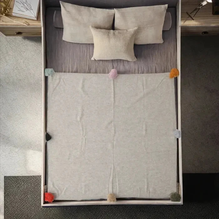 Luxury cashmere throw blanket beautifully draped on a bed, adding warmth and comfort to the cozy space.
