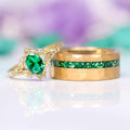 Maeve Emerald Couples Ring Set by Aquamarise, featuring nature-inspired gold wedding bands with a radiant emerald and matching green gemstone inlay, elegant and meaningful jewelry for couples.