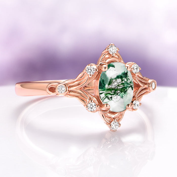Maeve Green Moss Agate Ring- 14K Solid Rose Gold featuring an intricately carved rose gold band adorned with small sparkling white stones surrounding a unique oval green moss agate gemstone, by Aquamarise Gold.