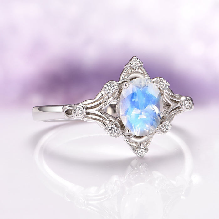 Maeve Vintage Moonstone Engagement Ring in 14K White Gold by Aquamarise Gold, featuring an oval moonstone with glowing blue flashes set in an ornate vintage-inspired band accented with delicate diamond details, part of Solid Gold Engagement Rings and Nature-Inspired Engagement Rings collections.