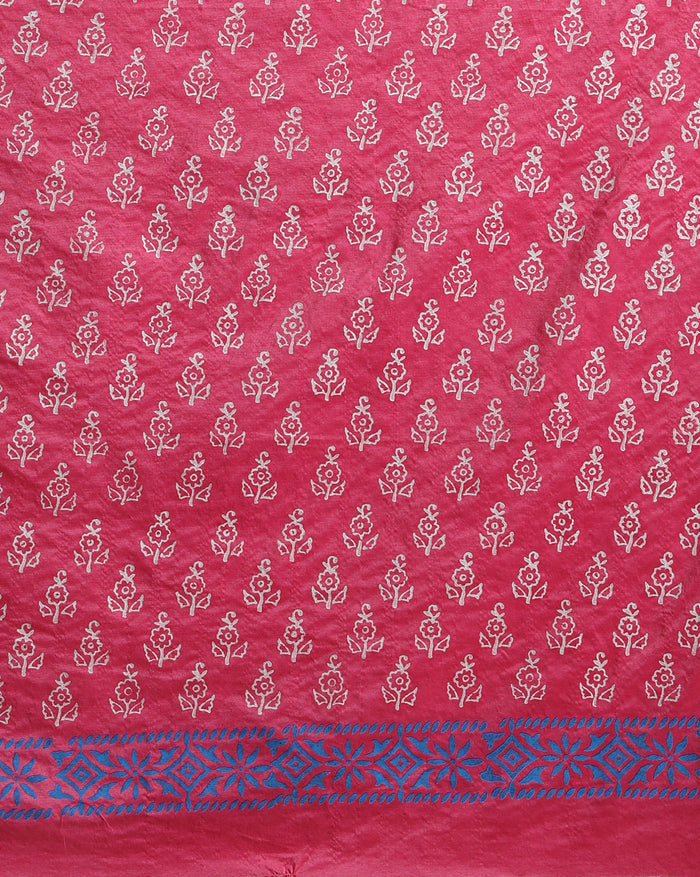 Magenta katan silk unstitched suit set with small white floral hand block print, a solid magenta piece, and a dupatta with wide blue geometric border and metallic-toned edge.