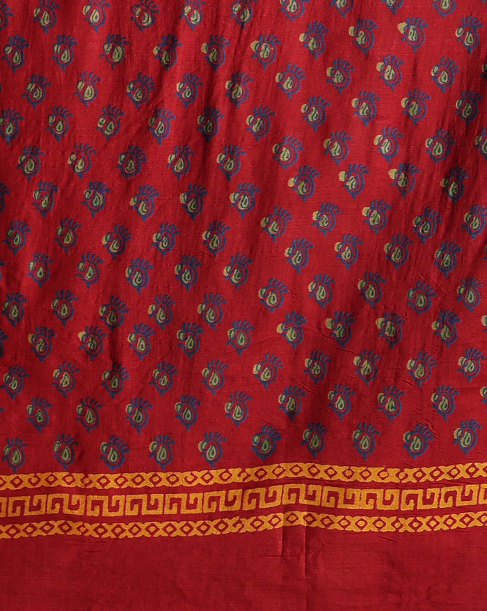 Maroon katan silk unstitched suit set hand block printed with small turquoise botanical motifs and angular geometric key-pattern bands at the ends.