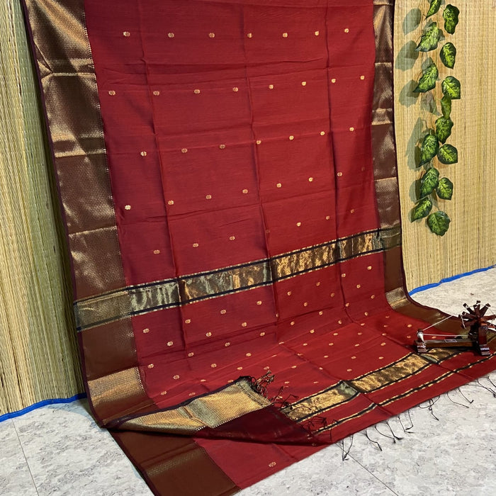 Maroon Maheshwari silk saree with small gold buti across the body and a wide checked gold and black border, handwoven in Maheshwar