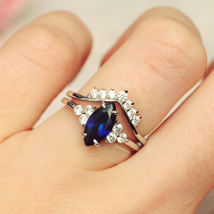 Marquise Cut Blue Sapphire Bridal Ring Set in Sterling Silver showcasing a deep blue marquise sapphire nestled with sparkling clear accents on a polished sterling silver band by Aquamarise.