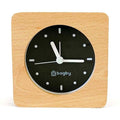 Minimalist silent alarm clock with wooden frame and non-numbered dial in light color.