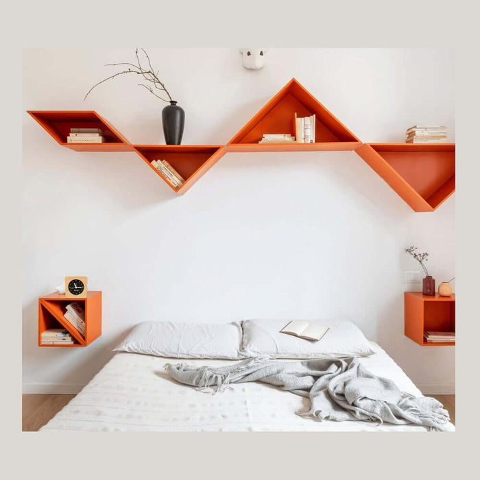 Minimalist silent alarm clock on bedside table in a modern bedroom with orange wall shelves and cozy decor.