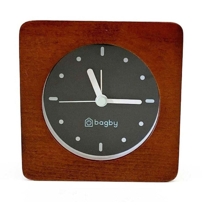 Minimalist silent alarm clock with dark wooden frame and non-numbered dial, featuring built-in night light.
