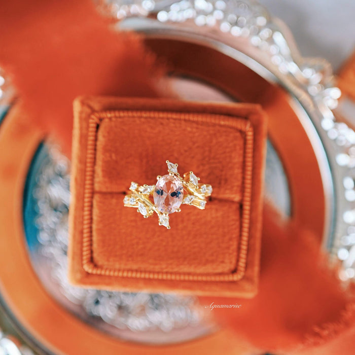 Pink Lab-Grown Diamond Fairy Leaf Engagement Ring in 14K Solid Yellow Gold (IGI Certified) by Aquamarise Gold, featuring an oval pink lab-grown diamond surrounded by delicate leaf-inspired white diamond accents, displayed on a burnt orange velvet ring box with a silver decorative tray, part of the Solid Gold Engagement Rings, April Birthstone Jewelry, and Nature-Inspired Engagement Rings collections.