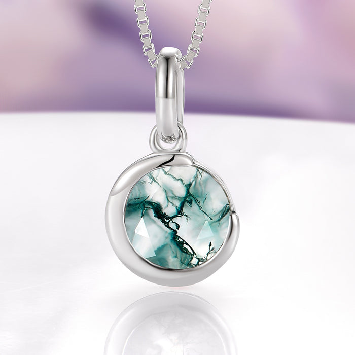 Moss Agate Crescent Moon Necklace in Sterling Silver by Aquamarise, featuring a polished crescent moon design embracing a round, faceted natural moss agate gemstone, part of Moss Agate Jewelry, Necklaces, and Meaningful Jewelry Gifts collections.