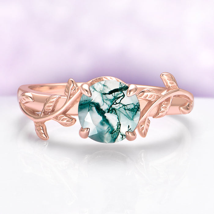 Rose gold ring with a green gemstone on a light purple background