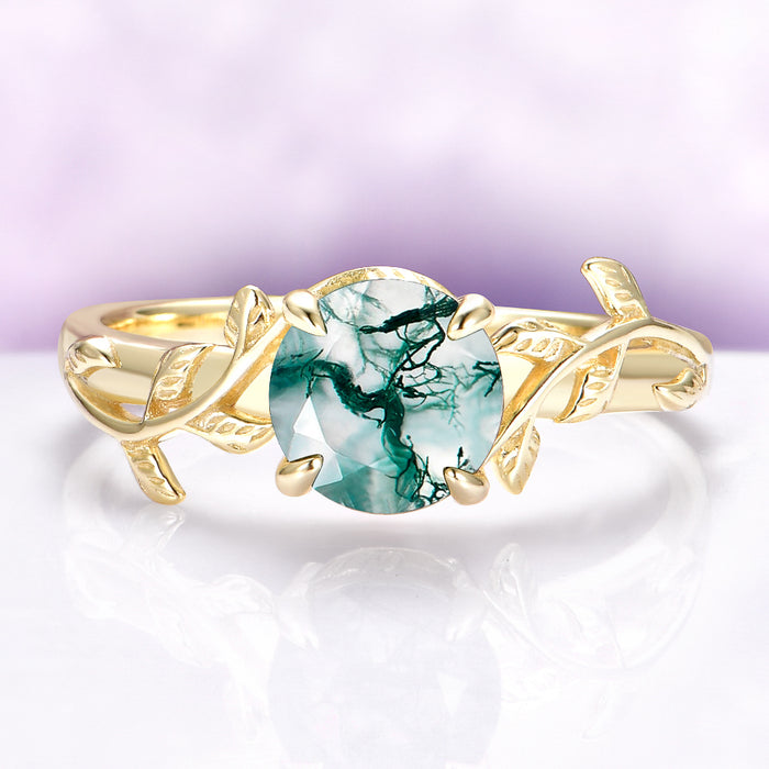 Gold ring with a green gemstone on a white and purple gradient background