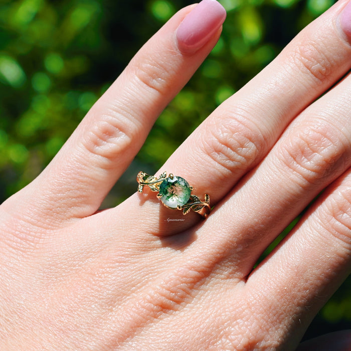 Moss Agate Leaf Ring in 14K Yellow Gold Vermeil by Aquamarise, featuring a delicate nature-inspired band with a round green moss agate centerpiece on a hand against a natural background.