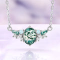 Moss agate and opal cluster necklace in sterling silver with an oval green moss agate center and white opal accents