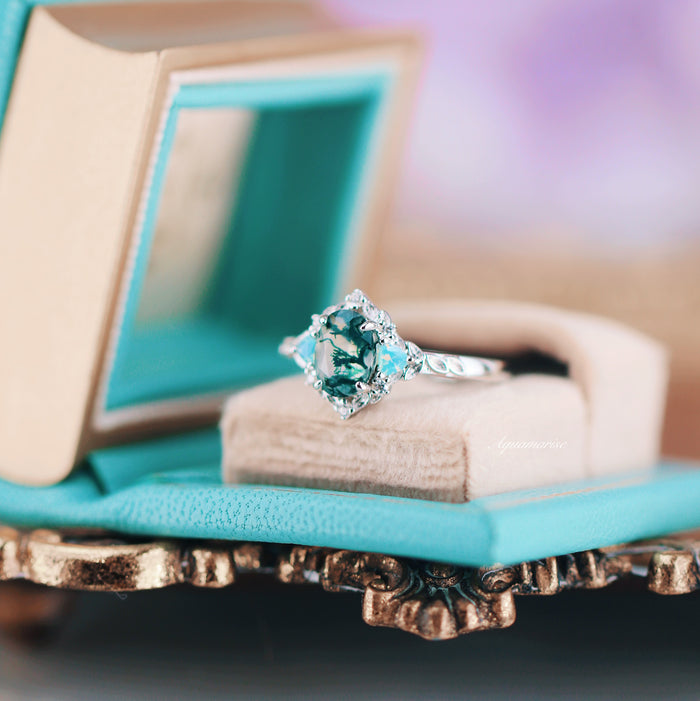 Moss Agate & Opalescent Sapphire Engagement Ring in 14K White Gold by Aquamarise Gold featuring a nature-inspired moss agate stone with sapphire accents on an engraved band displayed in a turquoise box.