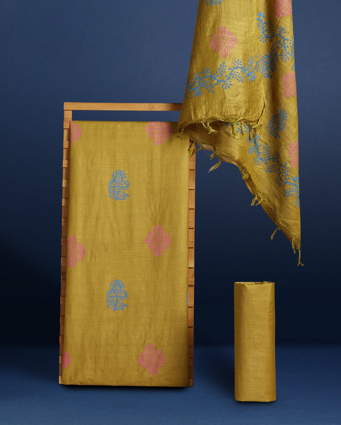 Mustard yellow katan silk unstitched suit set with sparse pink and blue floral hand block print and a raw fringed dupatta edge