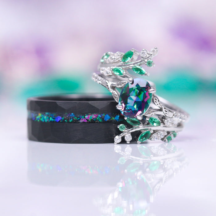 Mystic Topaz & Galaxy Opal Leaf Couples Ring Set featuring a silver nature-inspired ring with multicolor topaz and green stones and a black band with a galaxy opal inlay by Aquamarise.
