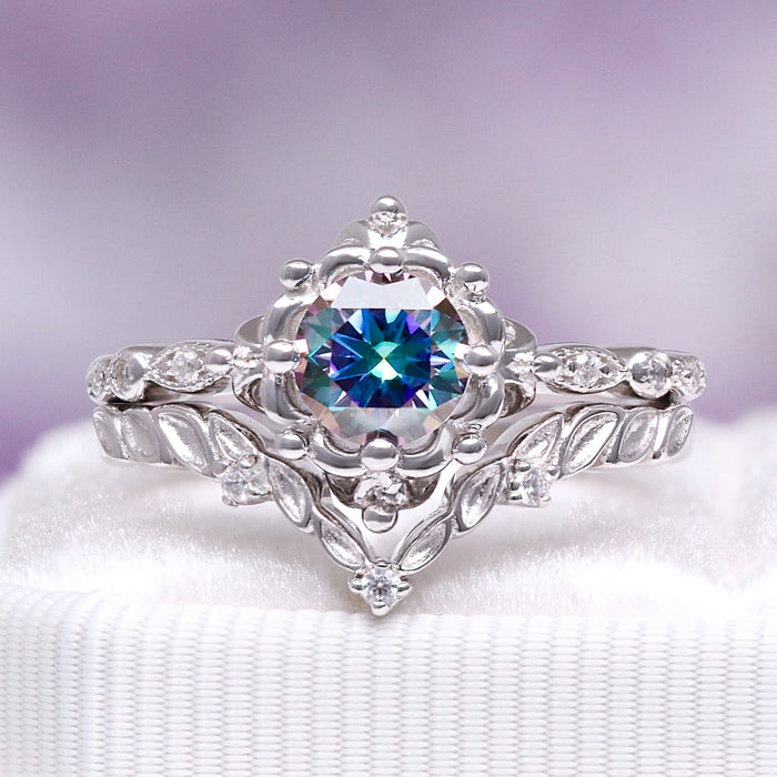 Silver ring with a colorful gemstone on a white cushion against a purple background