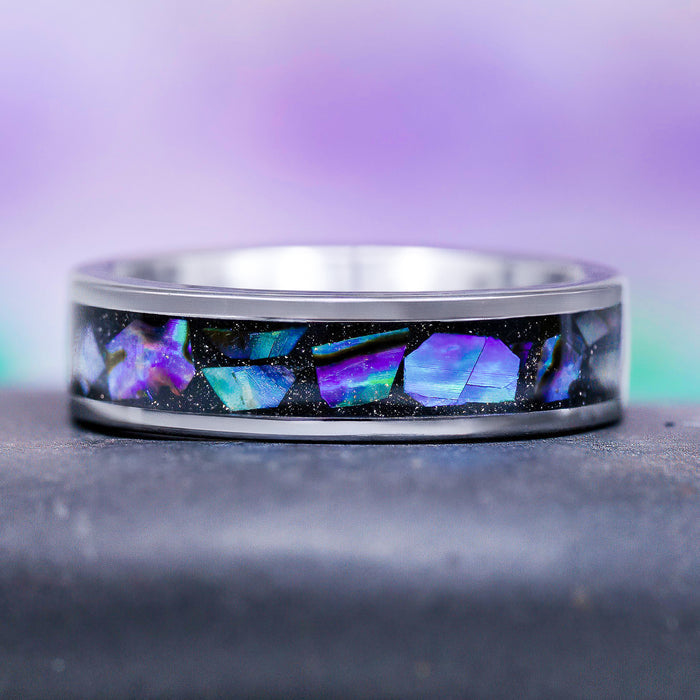 Natural Paula Shell Wedding Band in Tungsten (6MM) by Aquamarise, featuring a crushed natural Paula shell inlay with iridescent blue and purple tones set against galaxy blue sandstone, from collections including Men’s and Women’s Wedding Bands and Nature-Inspired Jewelry.