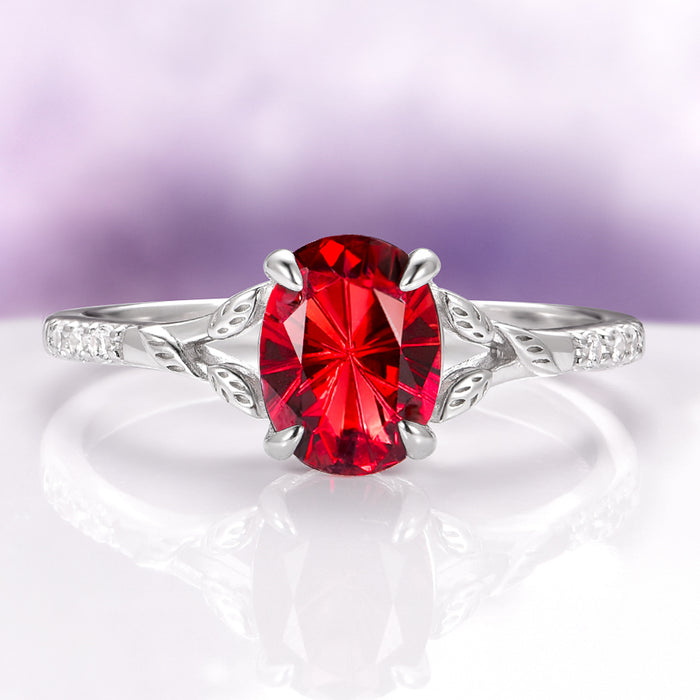 Fireworks Cut Natural Red Garnet Leaf Engagement Ring in 14K White Gold by Aquamarise Gold, featuring a vibrant oval red garnet with intricate leaf-inspired white gold detailing and small diamond accents, part of Solid Gold Engagement Rings and January Birthstone Jewelry collections.