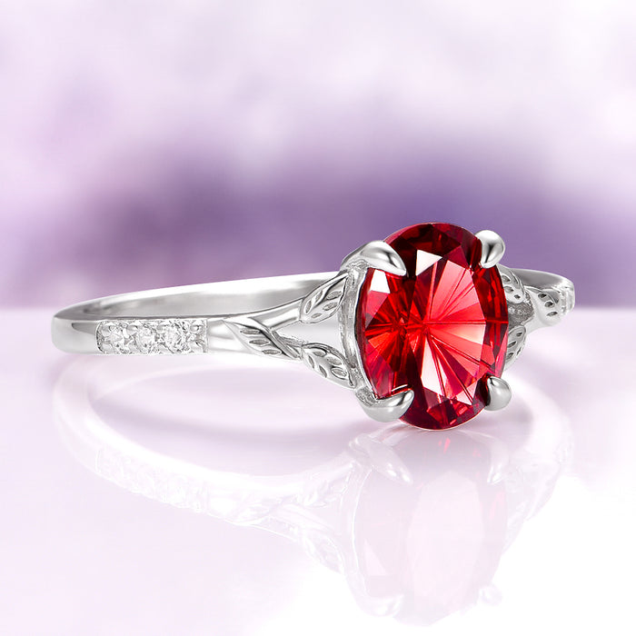 Fireworks Cut Natural Red Garnet Leaf Engagement Ring in 14K White Gold by Aquamarise Gold, featuring a fiery oval red garnet with delicately engraved leaf motifs and small diamond accents, perfect for unique nature-inspired engagement jewelry.