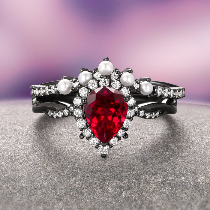Briar Natural Red Garnet & Pearl Ring Set in Black Ruthenium featuring a pear-shaped garnet, freshwater pearls, and sparkling stones on a twisted black ruthenium band by Aquamarise.