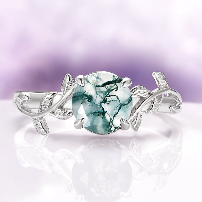 Natural Green Moss Agate Leaf Ring in Sterling Silver by Aquamarise featuring a vintage-inspired design with a round green moss agate stone and delicate leaf motifs on the band.