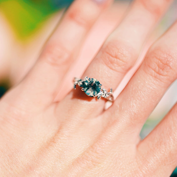 Natural Green Moss Agate Leaf Ring in Sterling Silver by Aquamarise, featuring a round moss agate stone with green inclusions and intricate leaf-inspired silver detailing on the band.