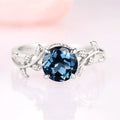 London Blue Topaz Leaf Ring- 14K White Gold by Aquamarise Gold, featuring a deep blue topaz with detailed leaf and vine accents, part of nature-inspired and birthstone jewelry collections.