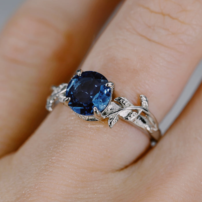London Blue Topaz Leaf Ring- 14K White Gold by Aquamarise Gold featuring a deep blue topaz set in a delicate white gold band with leaf and vine details from the November Birthstone collection.