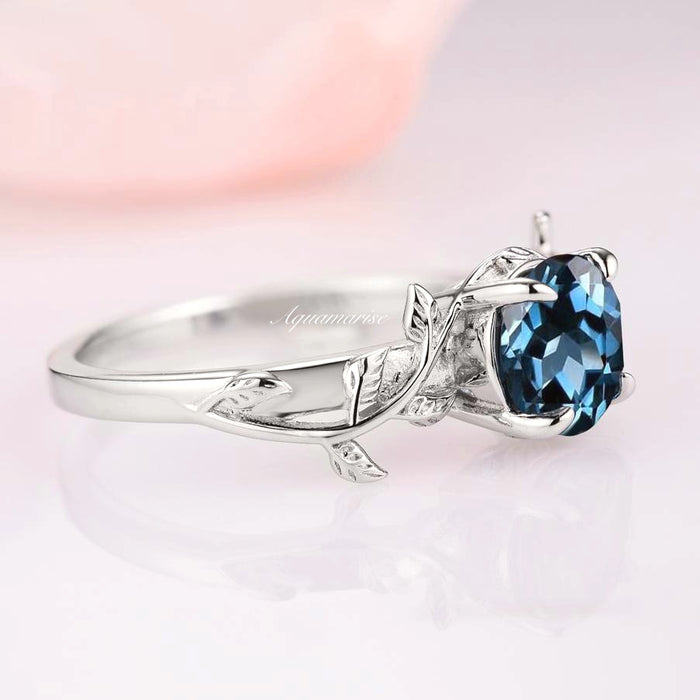 London Blue Topaz Leaf Ring- 14K White Gold by Aquamarise Gold featuring an oval natural blue topaz with delicate leaf and vine engravings on a polished white gold band.