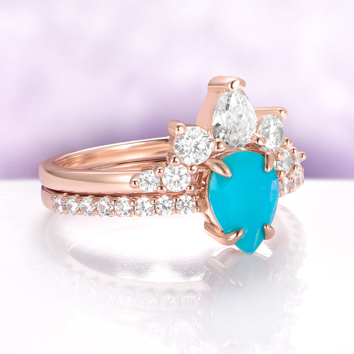 Rose gold ring with a turquoise heart-shaped gemstone on a white surface with a purple background