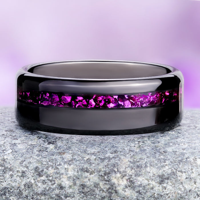 Crushed ruby black tungsten wedding band on granite, magenta-red inlay against the mirror-polished band