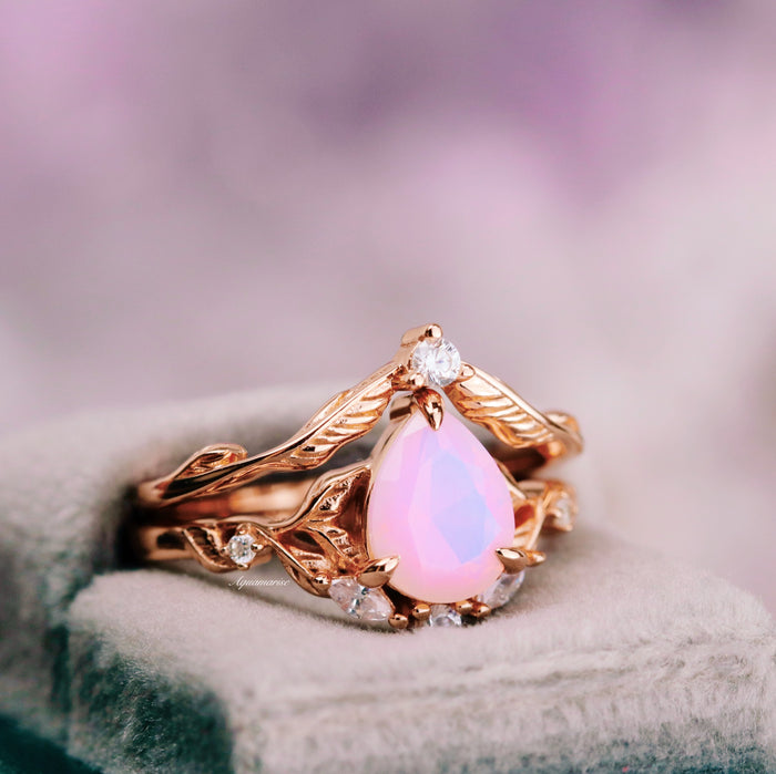 Opalescent Pink Sapphire Engagement Ring Set in 14K Rose Gold Vermeil by Aquamarise featuring a pear-shaped pink sapphire and delicate diamond accents on intricately designed rose gold bands.
